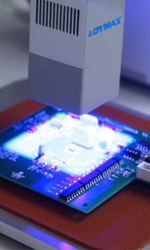 A Dymax UV light-curing lamp curing a printed circuit board.