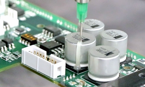 Dymax 9773 low outgassing adhesive is dispensed onto a printed circuit board to ruggedize a component.